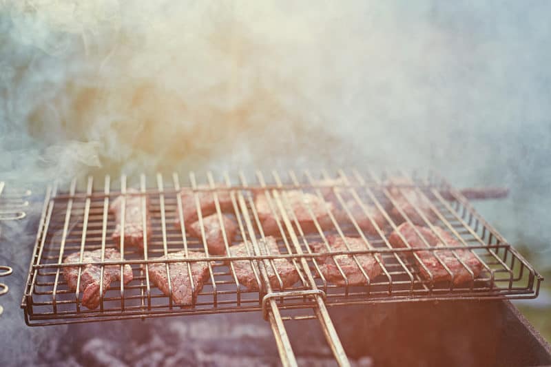 Barbecue with meat in metal grate